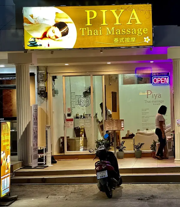 The Piya Thai Massage shopfront at night with its gold sign and open sign